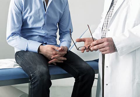 ST-Grid-Thumbnail-Prostate-Cancer - Smart-Fill Patient sitting on an exam table speaking with a doctor.